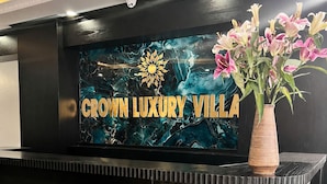 A reception desk with a sign that reads 'Crown Luxury Villa' and a 'Reception' sign below it. - Crown Luxury Hotel (Hanoi)