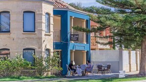 A building with a blue facade, a balcony with a sign, and outdoor seating. - Avalon Beach Escape| Coastal Retreat -5 minutes to beach, Spa, Sauna & Sleeps 11 (Wannanup)