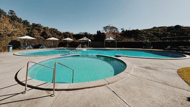 Una piscina con diseño circular, rodeada por una plataforma de hormigón.