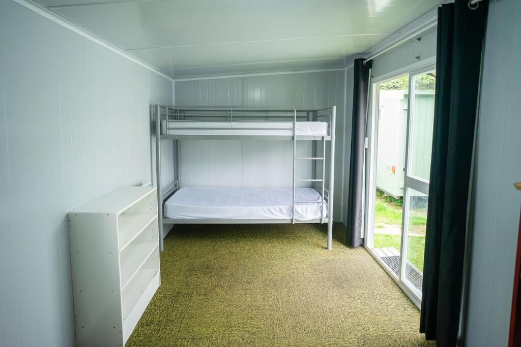 A bunk bed room with a window and a radiator.
