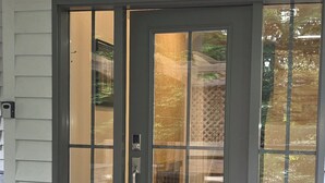 A front door with a sliding glass panel, a keypad lock, and a small step leading to the entrance. - Private Creekside Garden Suite - Patio, Deck, BBQ & Free Parking. Pet Friendly. (North Vancouver)
