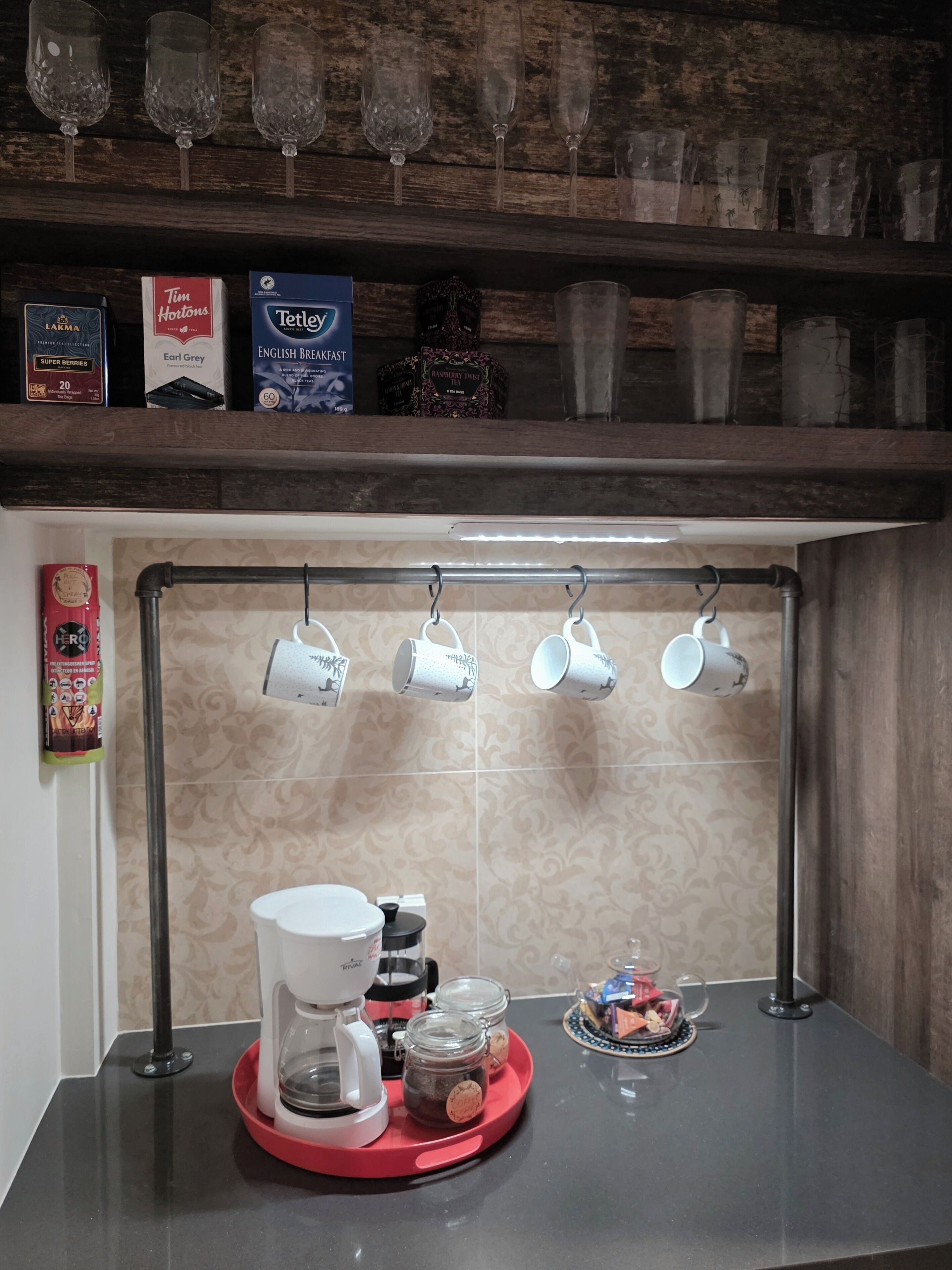 Una cucina con una macchina da caffè, barattoli e un vassoio sul bancone.