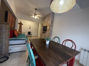 A dining area with a wooden table, chairs, a ceiling fan, and a woven light fixture. - Comfortable Apartment Near Salta City Center (Salta)