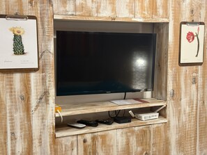 A television mounted on a wooden wall with a shelf below. - Comfortable Apartment Near Salta City Center (Salta)