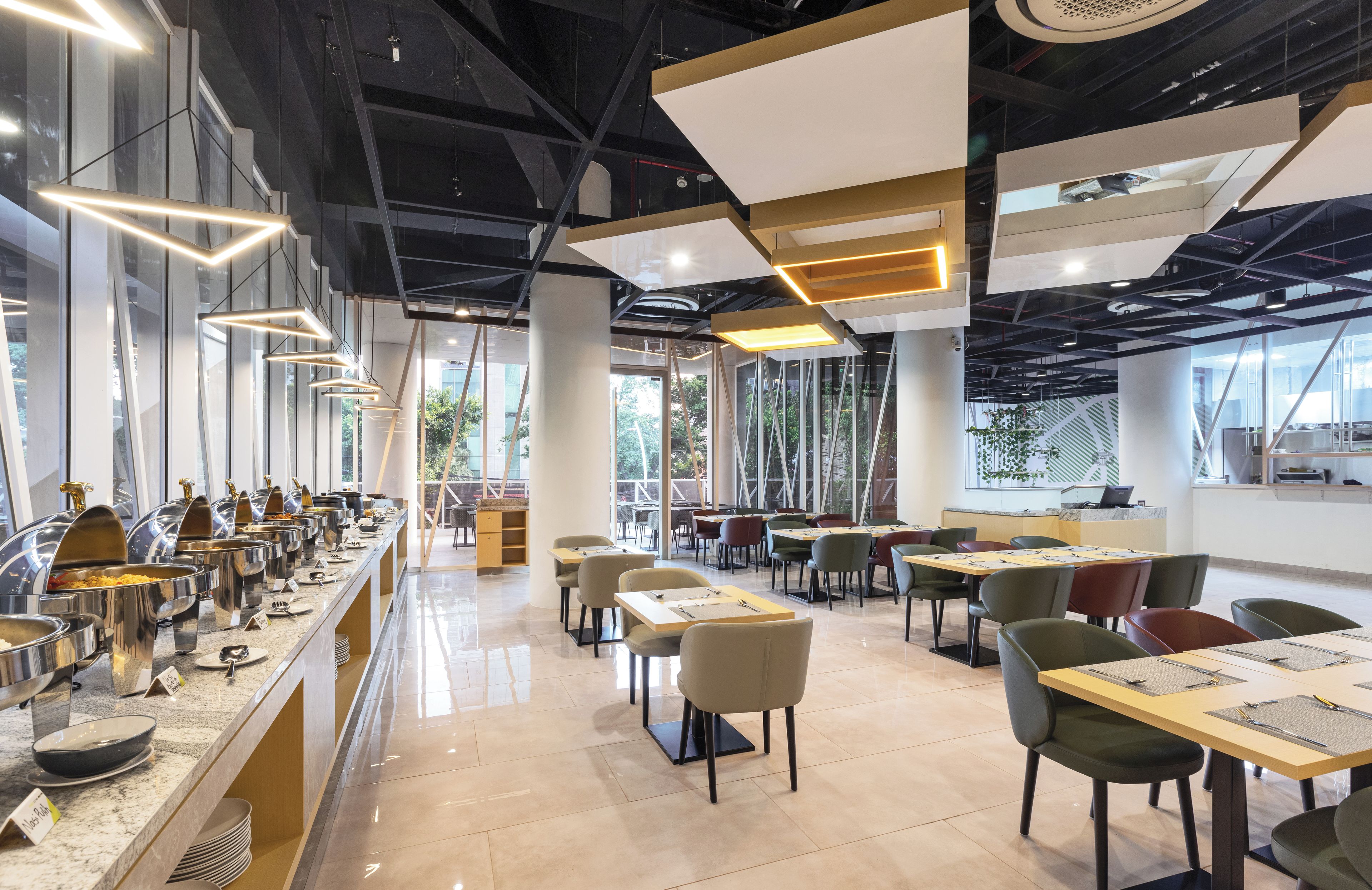 Un comedor moderno con una barra de buffet, varias mesas y sillas.