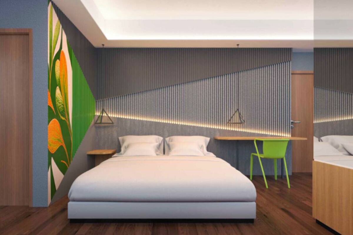 Un dormitorio moderno con una cama grande, un escritorio y una silla.
