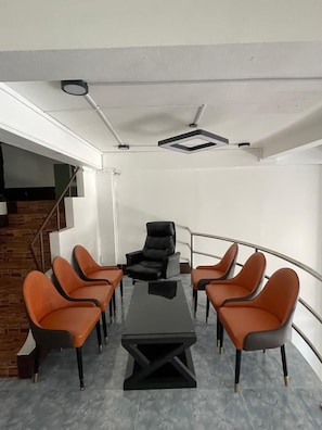 A conference room with a long table and six chairs, a staircase, and a white wall. - YT Hotel & Hostel Vientiane (Vientiane)