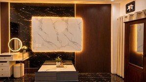 Un bagno moderno con un vanità in marmo, uno specchio grande e una lampada a parete.