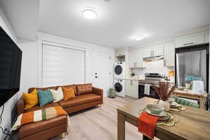 A modern apartment with a living room, kitchenette, and a dining area.