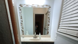A small bathroom with a toilet, sink, and mirror.
