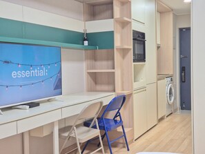 Eine moderne Küchenzeile mit eingebautem Backofen, Mikrowelle und Waschmaschine.
