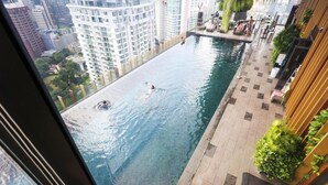Une piscine à débordement située sur le toit, offrant une vue sur les immeubles environnants.
