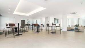 Moderni hotellin aula, jossa on keskeinen oleskelualue, vastaanottotiski ja taustalla sohva.