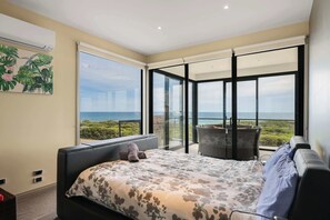 A bedroom with a bed, a window, and a balcony with a view of the ocean. - Amazing Ocean Views with Spa (Surf Beach)