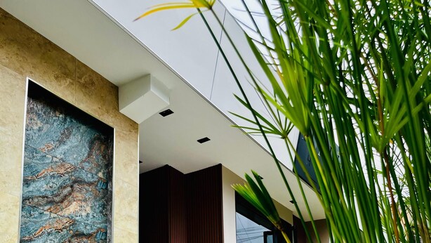 A modern building with a large abstract mural, a staircase leading to a balcony, and a potted plant. - Lumina Hotel Elegancia y confort (Armenia)