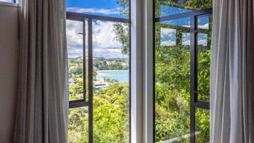A room with large windows offering a view of a lake and greenery.