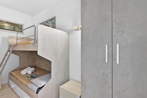A bunk bed with a ladder, a small bedside table, and a wardrobe with two doors. - Bono Deluxe: 3BR Home in Desenzano (Desenzano del Garda)