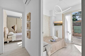 Une chambre moderne avec un lit, un téléviseur et une vue sur l’extérieur.
