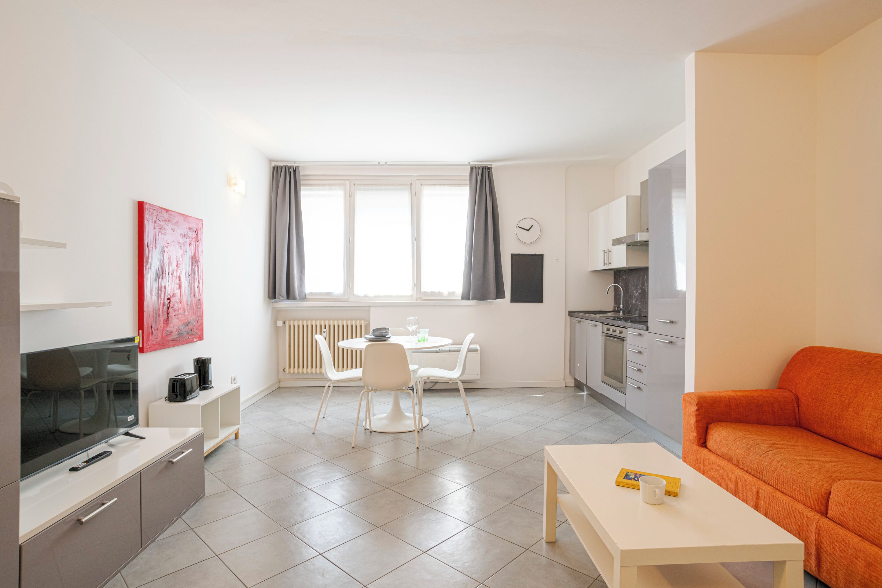 A modern apartment with a dining area, kitchen, and living space.