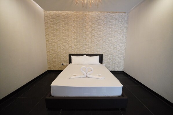 A modern hotel room with a large bed, a textured wall, and a minimalist design. - Tomorrowland Amata (Phan Thong)