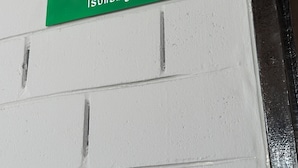 Uma placa verde com 'A20' e 'Bangkok' numa parede branca.