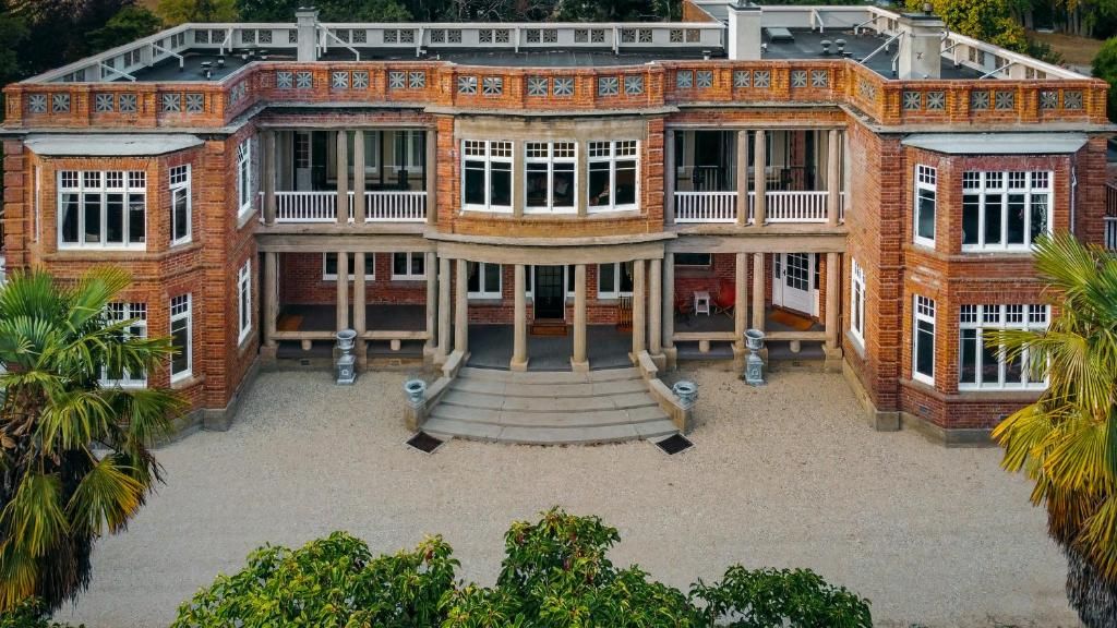 A large, multi-story building with a symmetrical facade, multiple balconies, and a central entrance with steps.
