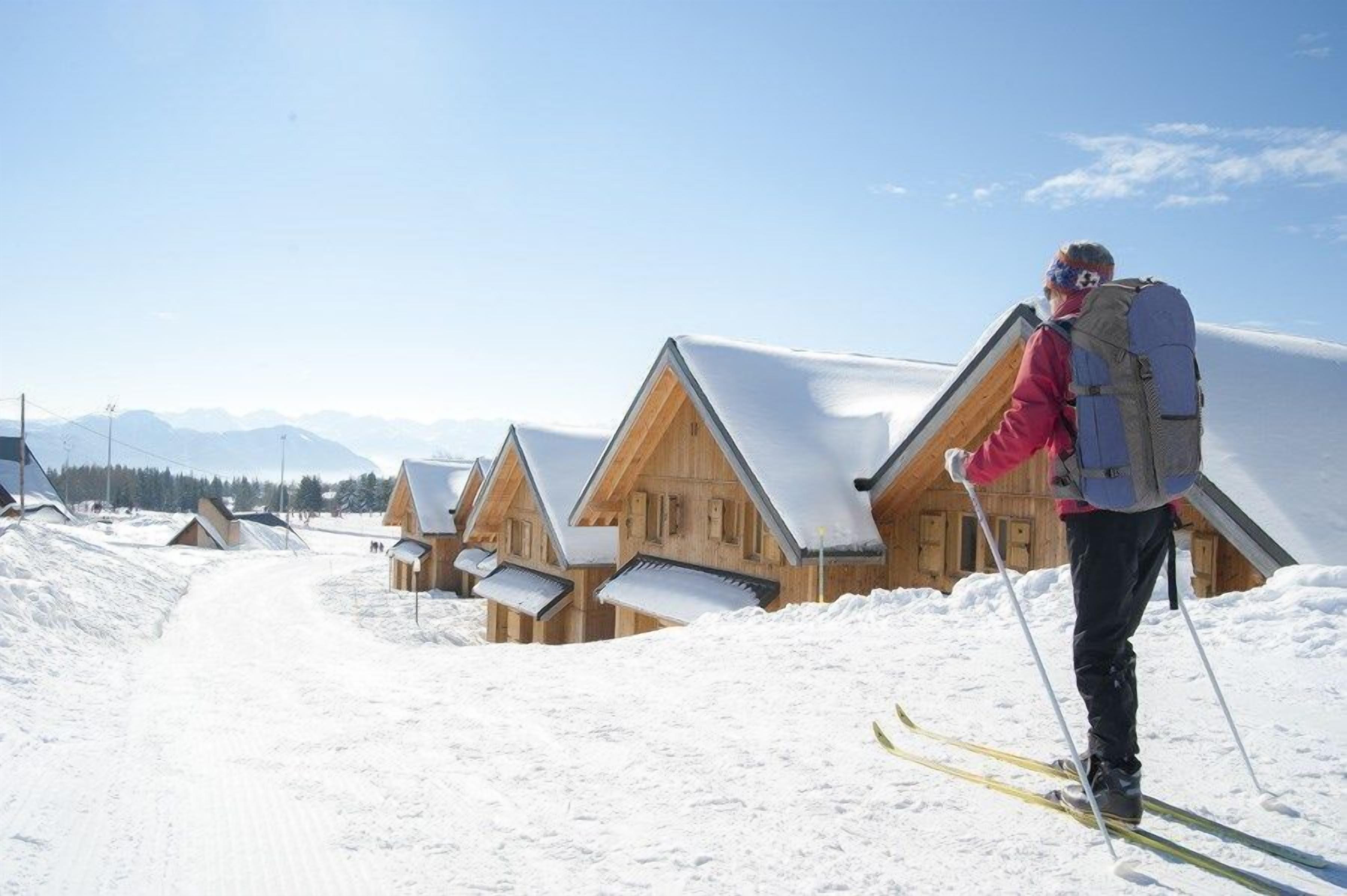 A wooden chalet-style building with a sloped roof, surrounded by snow.