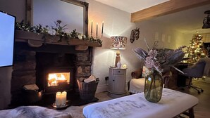 A cozy living room with a fireplace, a Christmas tree, and a comfortable seating area. - Rose Cottage, Cosy South Lake District Retreat, Sleeps 5 (Marton)
