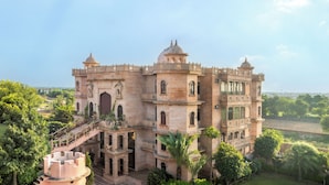 A large, historic building with multiple levels, ornate balconies, and a central dome. - Bijainagar Fort (Bijaynagar)