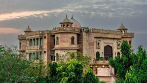 A historic building with multiple domes and arched windows, surrounded by greenery. - Bijainagar Fort (Bijaynagar)