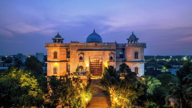 A large, historic building with a central dome and two smaller domes, surrounded by lush greenery. - Bijainagar Fort (Bijaynagar)