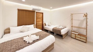 Una habitación de hotel con dos camas, un armario y un espejo.