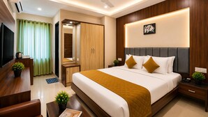 Une chambre d’hôtel comprenant un lit, des tables de chevet, un bureau, une télévision et un miroir.