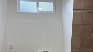 Kylpyhuoneessa on wc, pesuallas ja kylpyamme. WC:n yläpuolella on ikkuna ja oikealla puolella suihkutila.