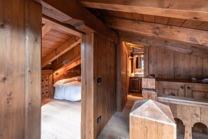Ein Holzinnenraum mit einem Bett, einer Küchenzeile und einem Flur.