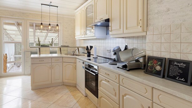 A kitchen with white cabinets, a built-in oven, and a backsplash. - Holiday Apartment An Der Lempe with Wi-Fi (Hofgeismar)
