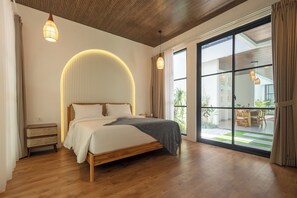 A bedroom with a bed, wooden flooring, a large window, and a view of the outdoors. - Uluwatu 2 Bedrooms villa with Rooftop (Kec. Kuta Sel)
