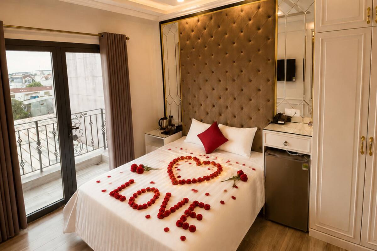 A hotel room with a bed, a dresser, a mirror, and a balcony.