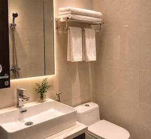 A modern bathroom with a sink, toilet, and a glass shower enclosure. - D'Élite Boutique Hotel Dĩ An (Di An)