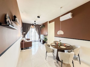 Ein modernes Wohnzimmer mit Essbereich, Deckenventilator und Klimaanlage.