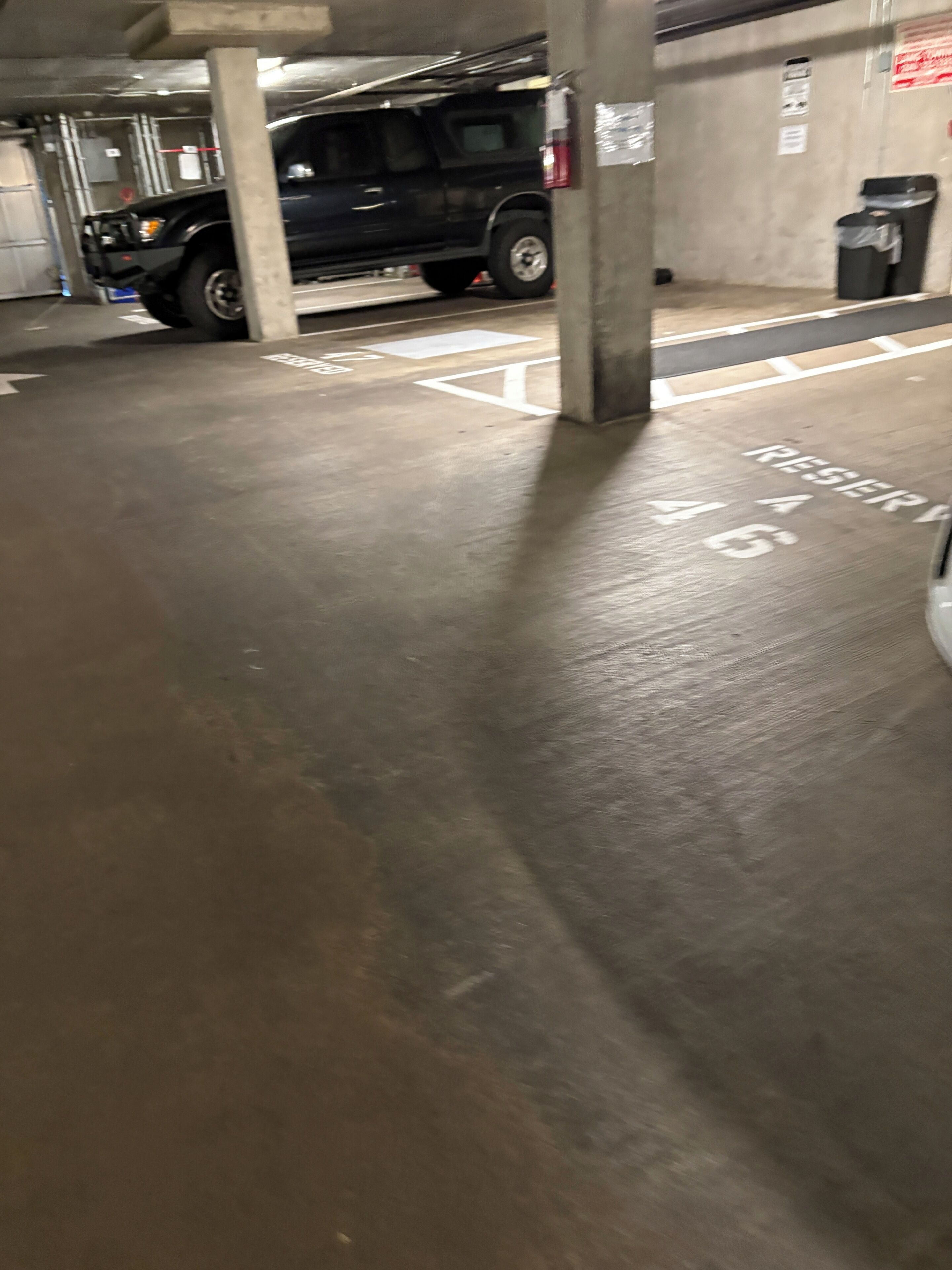 Uma garagem subterrânea com pilares de concreto e vagas demarcadas.