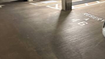 Uma garagem subterrânea com pilares de concreto e vagas demarcadas.
