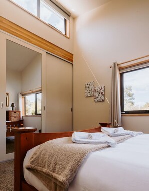 Ein Hotelzimmer mit Bett, Schreibtisch, Stuhl, Kleiderschrank und Fenster.