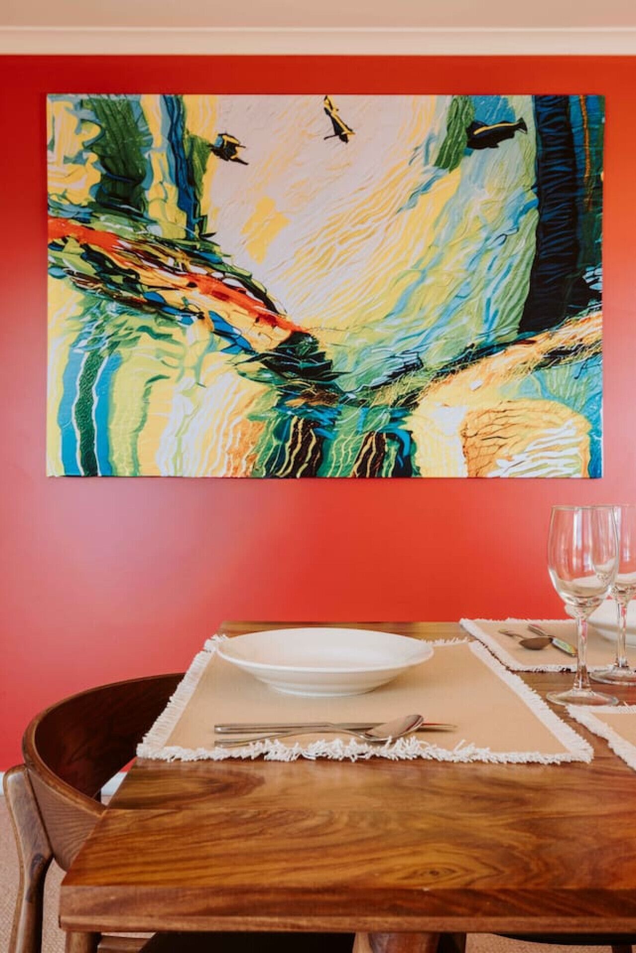 Une table à manger avec un set de table blanc, une assiette blanche et un verre à vin.