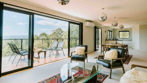 A spacious living area with large windows, a glass coffee table, and a dining area with a view. - Panorama Escape, Port Sorell (Port Sorell)
