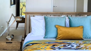 A bedroom with a bed, bedside table, lamp, and a view through an open door. - Panorama Escape, Port Sorell (Port Sorell)