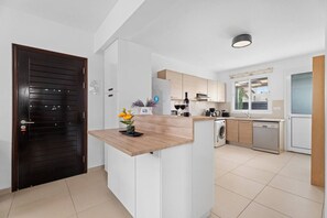 Una cocina moderna con encimera de madera, electrodomésticos integrados y vistas al exterior.