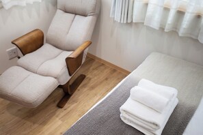 Ein Zimmer mit Massagegerät, einem kleinen Bett und einem ordentlich gefalteten Handtuch.