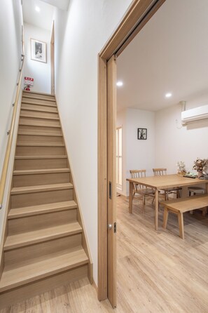 A wooden staircase leading to a dining area with a table and chairs. - shio (Osaka)