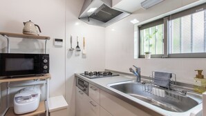 Una cucina moderna completa di microonde, fornello, lavandino e diversi utensili.
